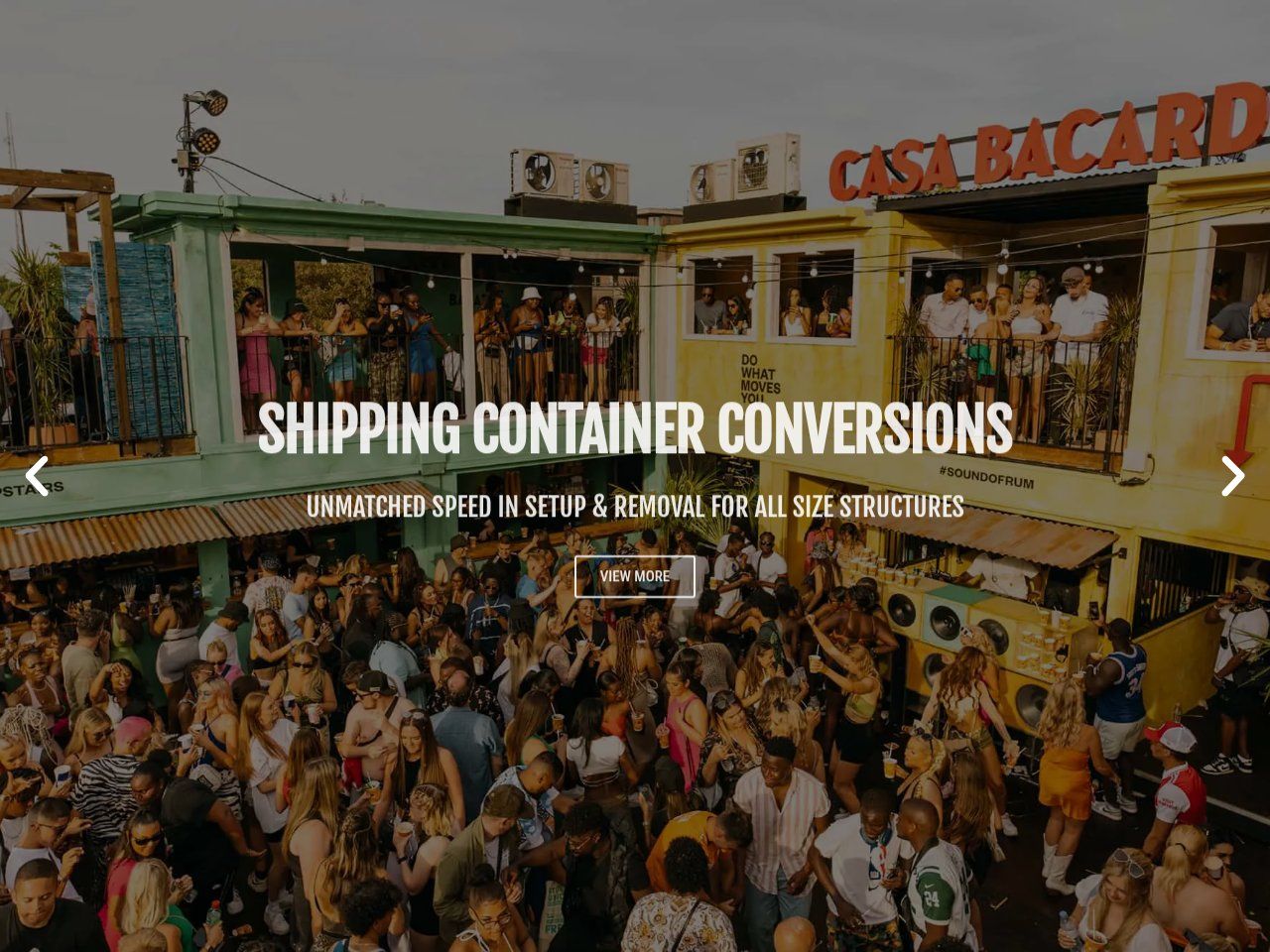 Shipping container conversions slide over a packed two-storey container bar with a View More button