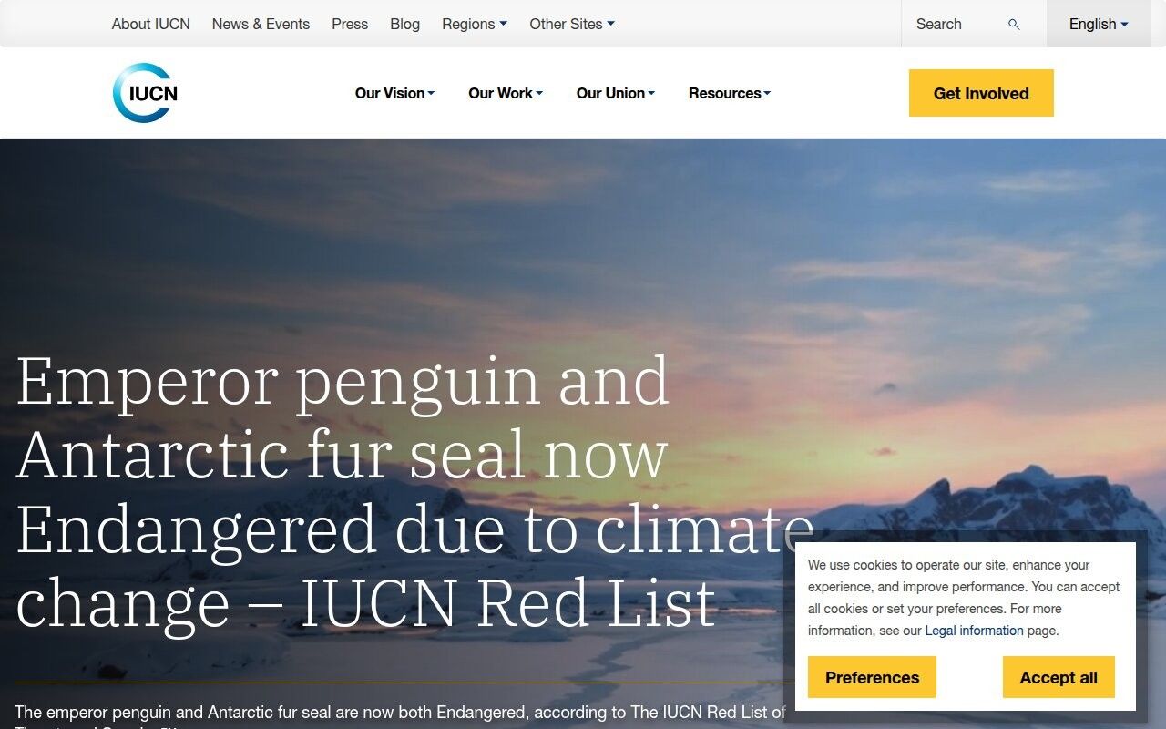 IUCN homepage hero on an Antarctic dusk reporting emperor penguin and fur seal Red List status
